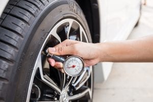 A person checking their tyres pressure
